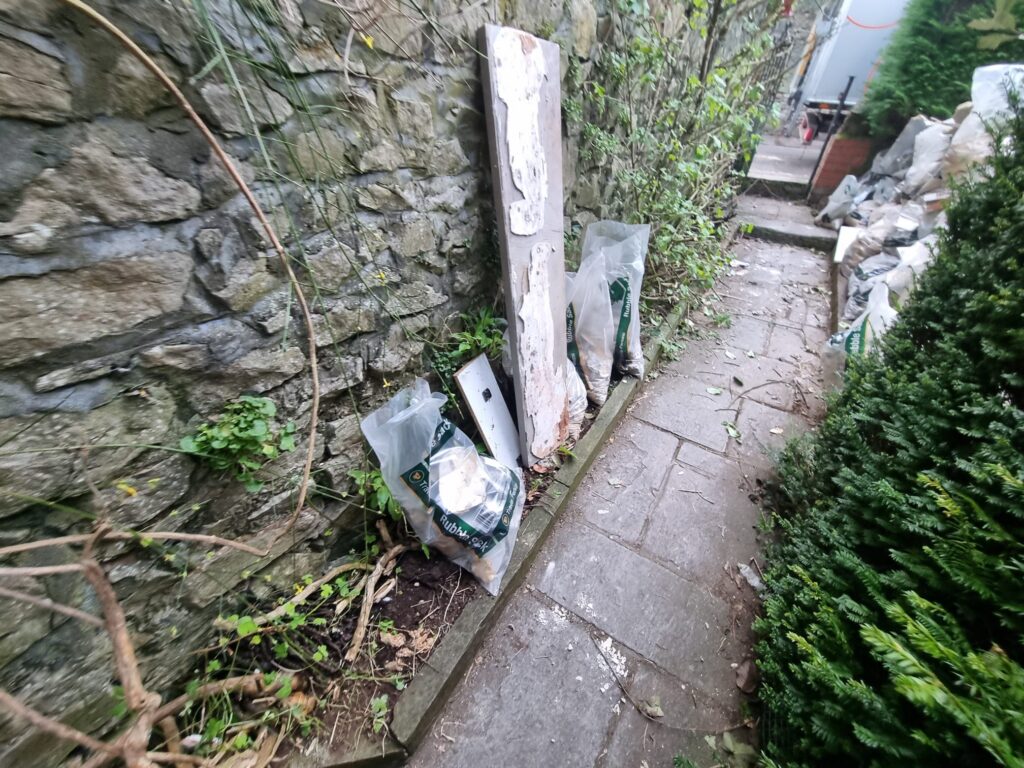 Garden clearance experts removing overgrown vegetation and debris